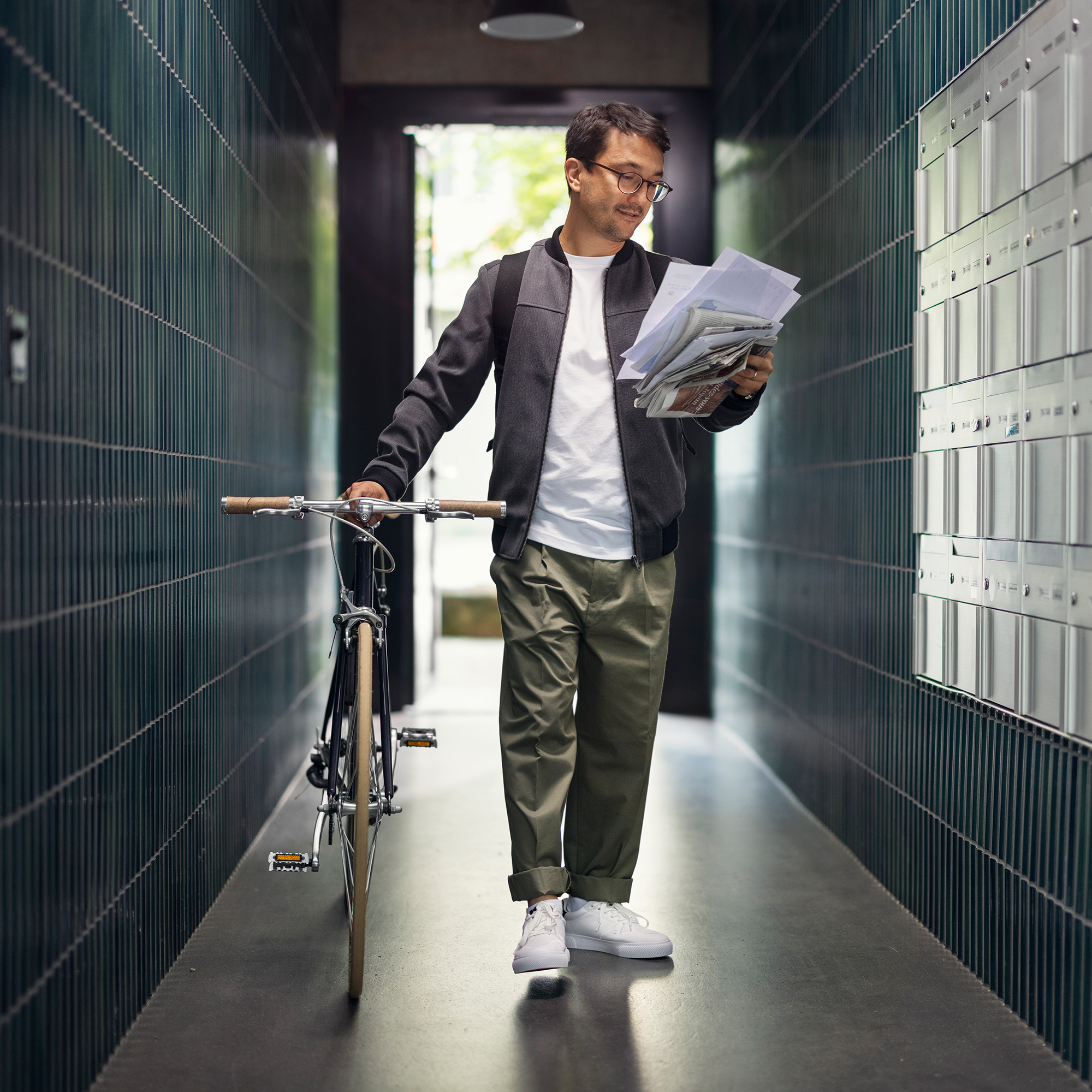 Junger Mann mit Fahrrad im Flur eines Hauses